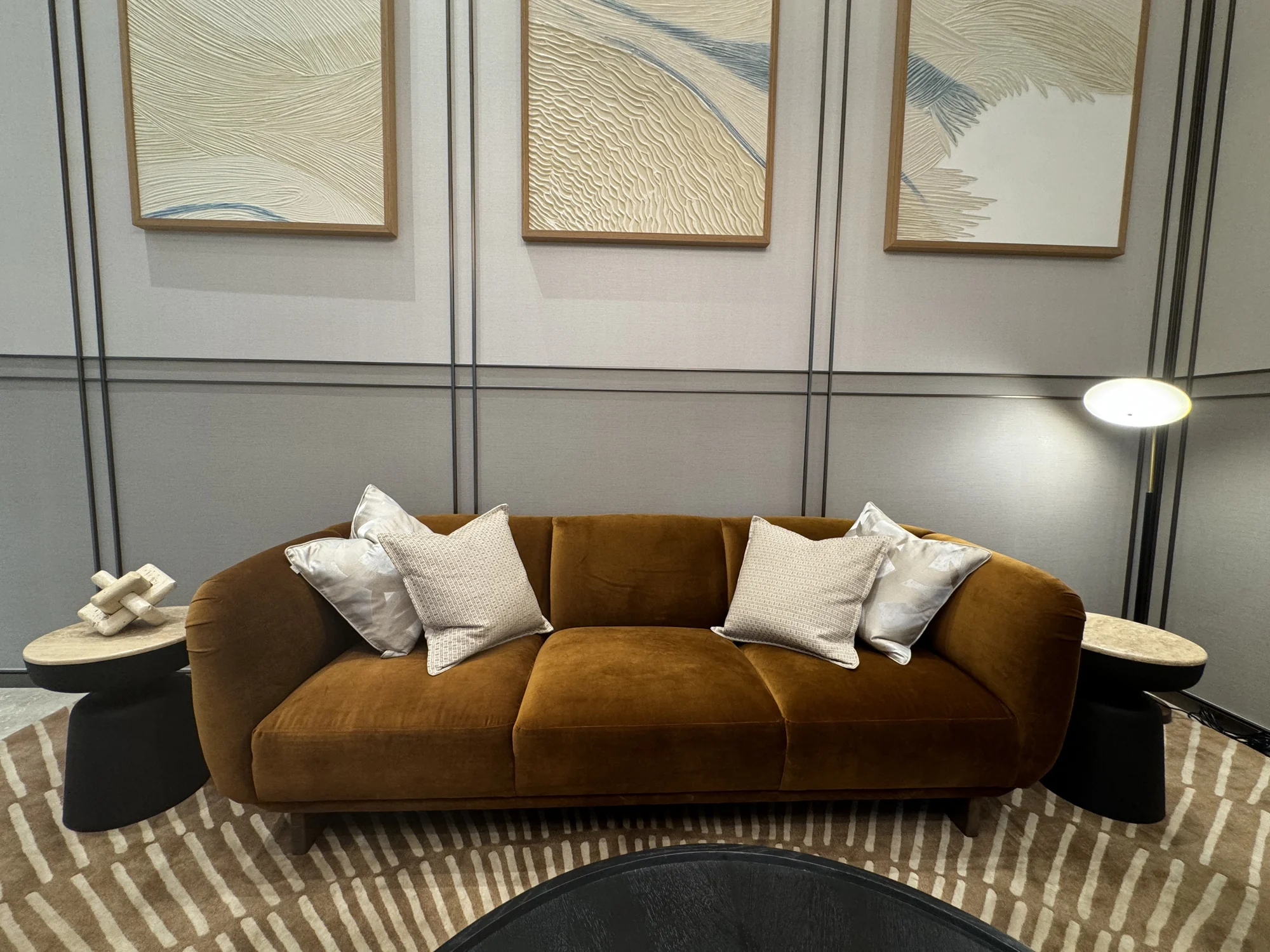 Custom curved sofa in caramel upholstery with ivory cushions